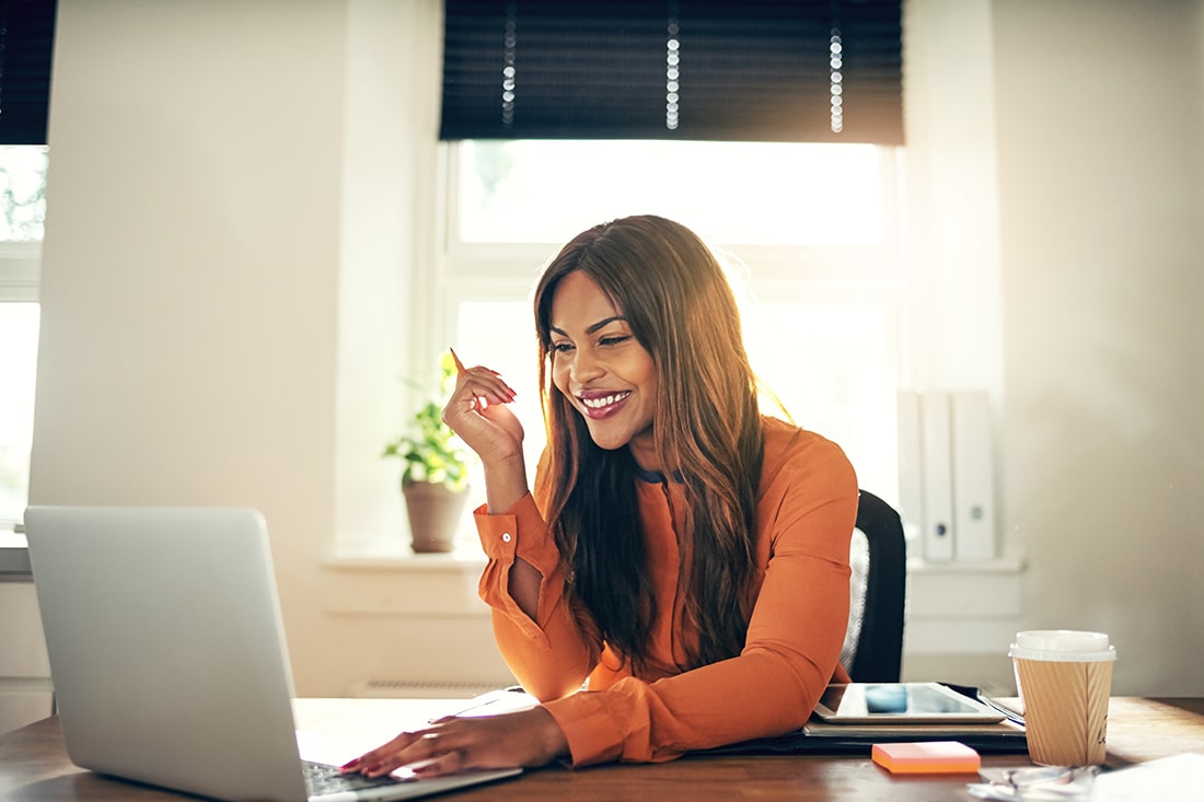 Woman smiling looking at her laptop