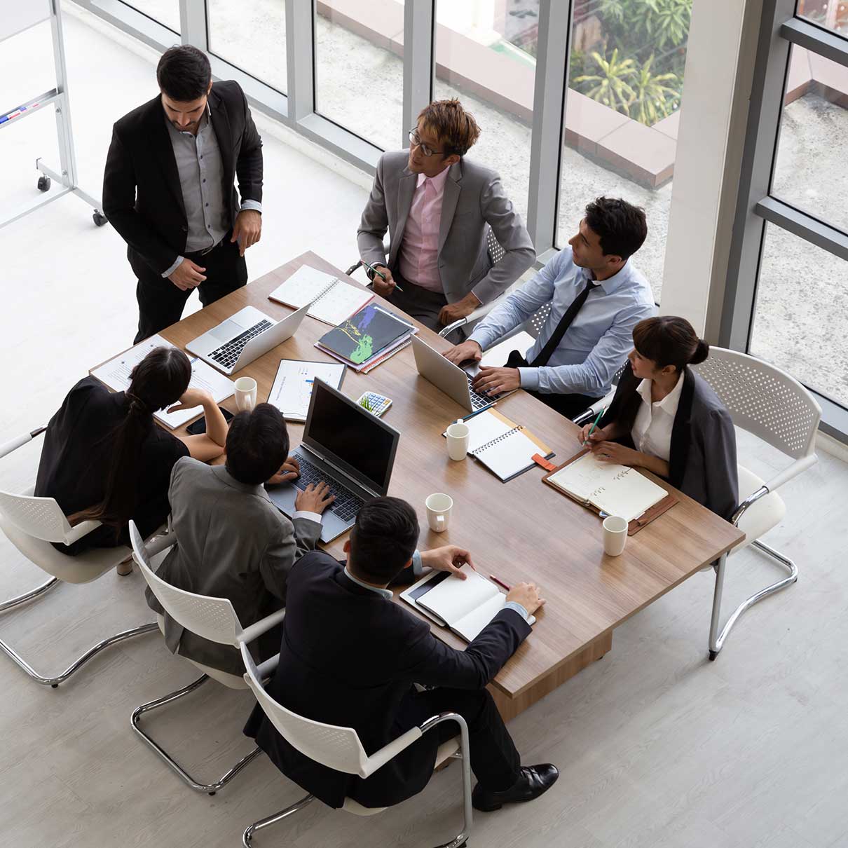 Colleagues in a meeting with laptops and project reports